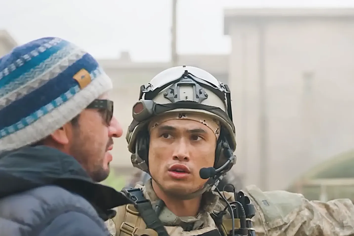 a man in military uniform talking to another man
